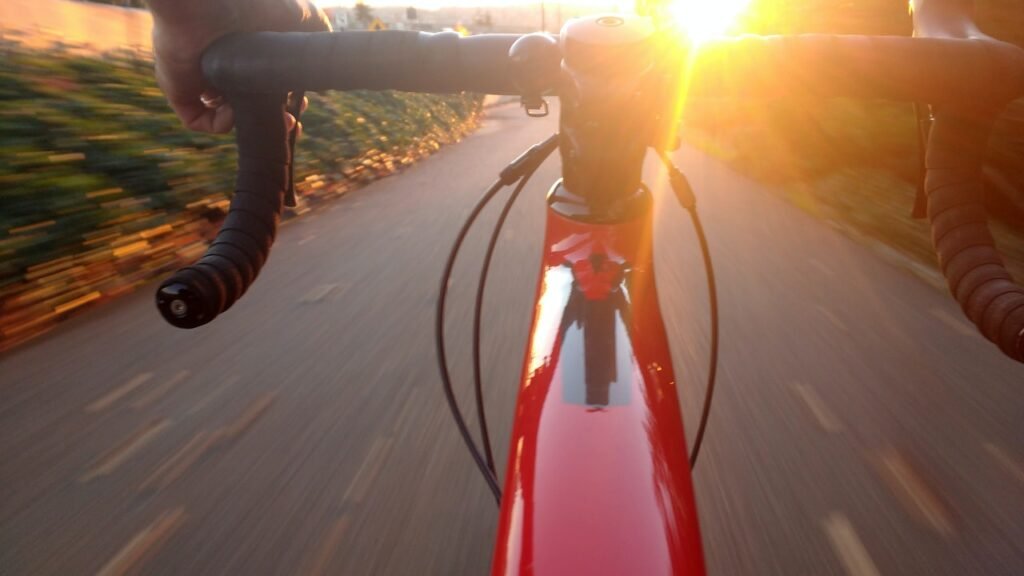 The handlebars of a bike, with the street in the background. Biking is another great form of exercise.