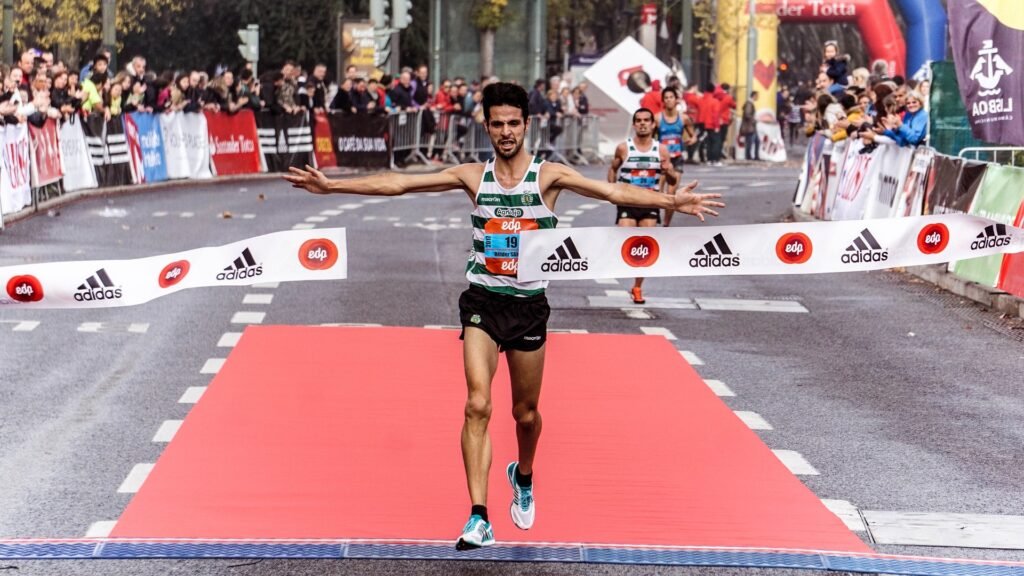 A man crossing the finish line, finishing strong after training on an empty stomach.