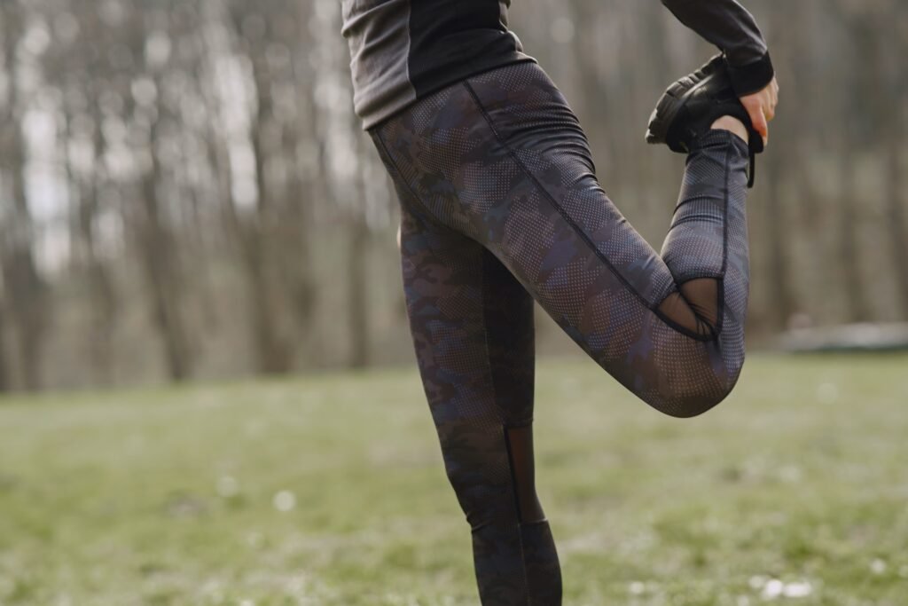 Close up of a woman stretching her quad. Trail running helps make a runner more resilient and injury-resistant.