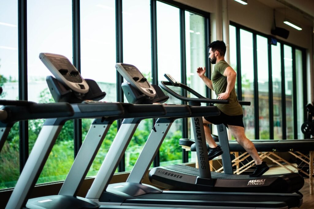 A man running on a treadmill, with several other treadmills in view. While you can go to a gym to run, you definitely don't have to.