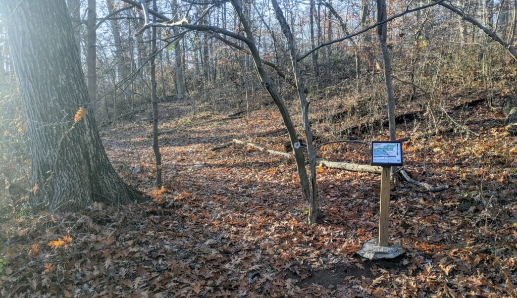 A sign post on the right side of the trail, where the Mayapple Loop Trail intersects the Lenape Trail.
