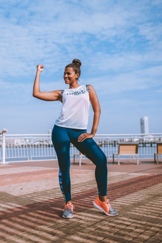 A woman in athletic gear, wearing a shirt that says, "Excuses?" Eliminating excuses is an important part of building a running habit.