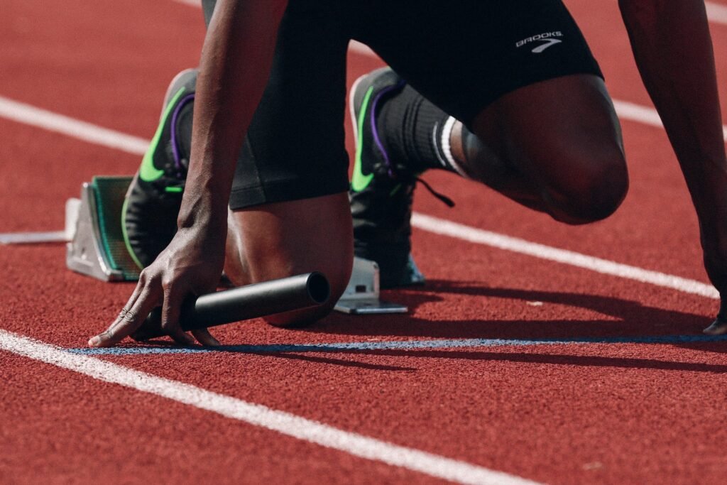 A runner on a track, about to start a relay. Embrace all paces, including fast and slow.