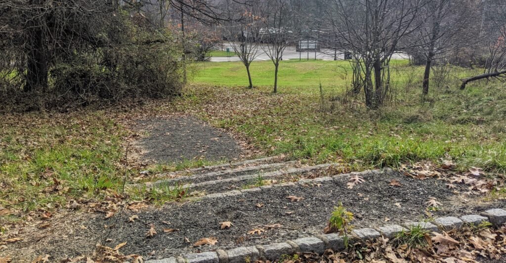 A set of stairs leading to a grassy hill.