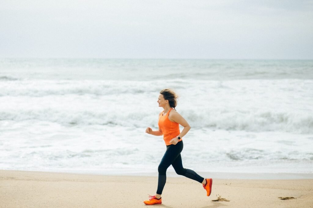A woman running outside at the beach for her mental health.