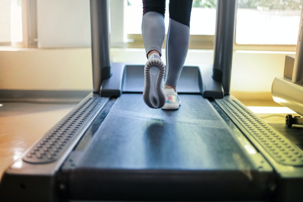 Close up of a woman's feet running on a treadmill belt. A treadmill belt is one of the most important features on a treadmill.