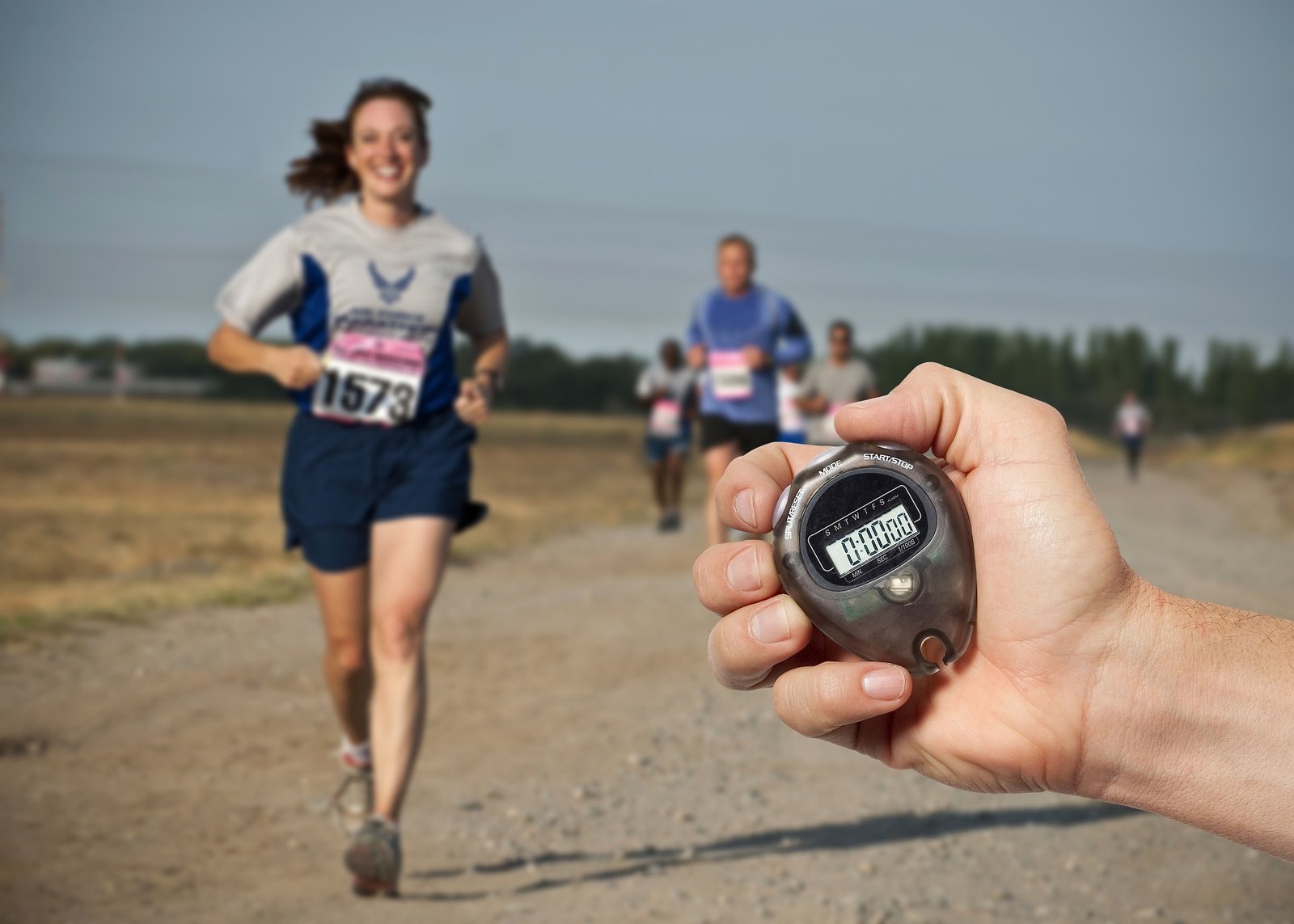 A woman running, and a man holding an old stopwatch. It's time to upgrade to a real GPS running watch!