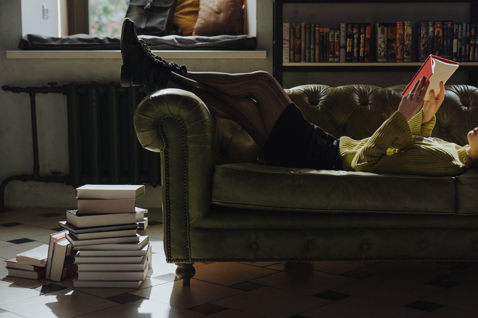 A woman on a couch reading a book, the Science of Running.