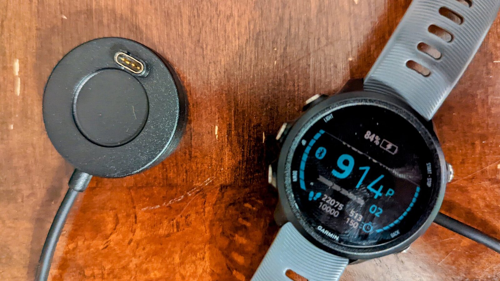 A Garmin watch sitting on a charger.