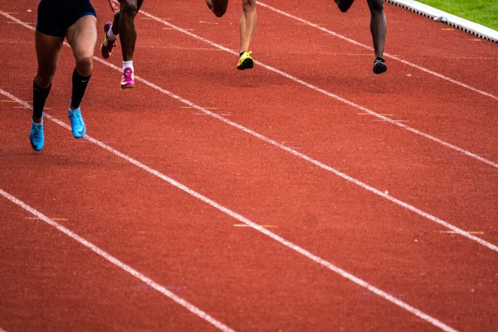 A group of runners running on a track. With a Pfitz marathon training plan, you don't necessarily need to run your workouts on a track - but you can if you want to.