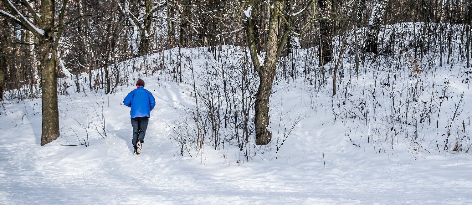 A man running in the snow, training for a marathon.