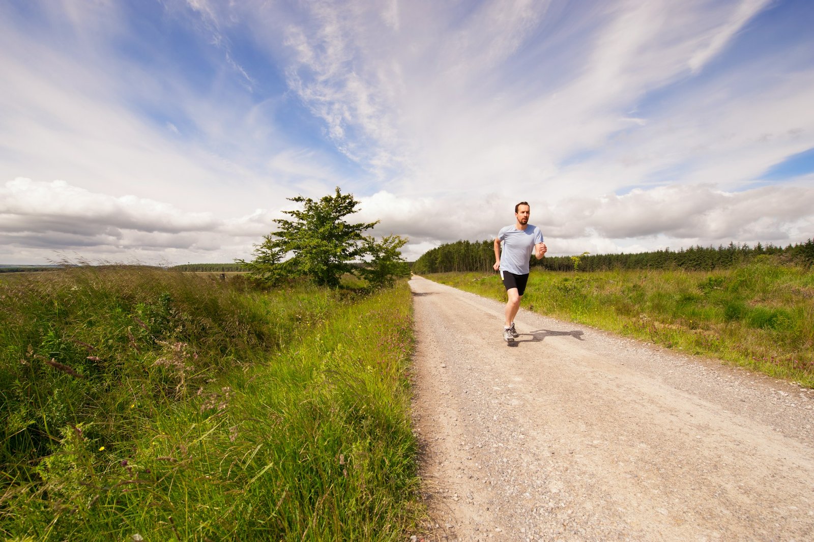 A man running down a dirt path in the summer sun and heat