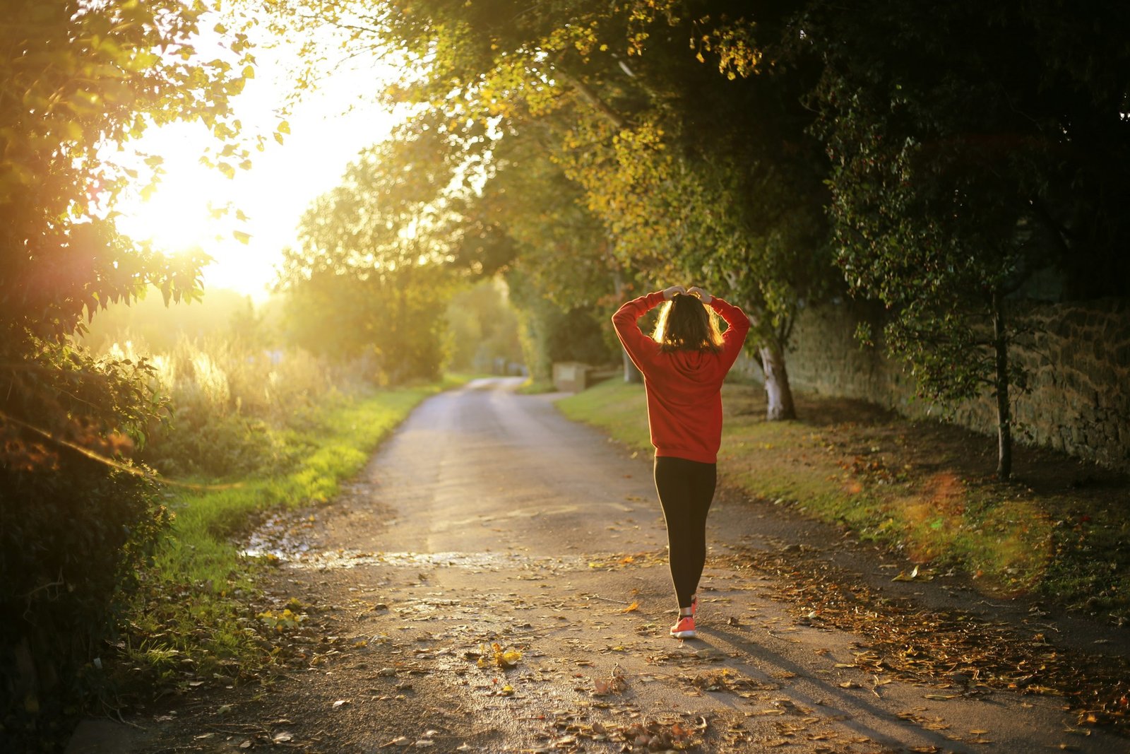 A woman walking down a trail in the forest. It's normal to run slowly after your first marathon. It takes time to recover.