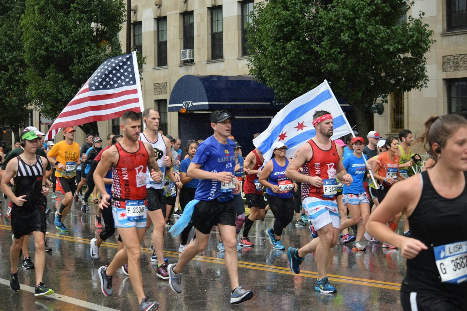 Runners in a marathon carrying a US flag